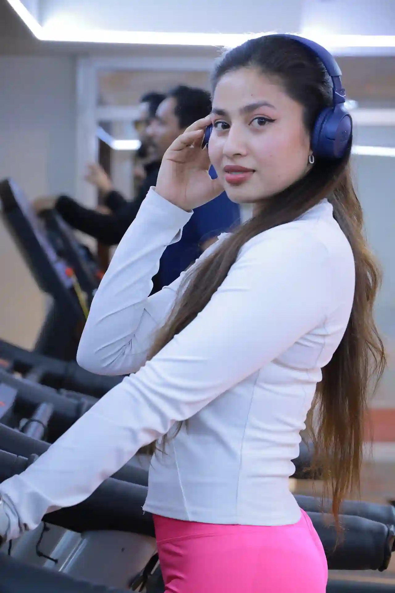 Woman wearing headphones on a treadmill at Zarya Wellness Health Club, a gym in Al Qusais